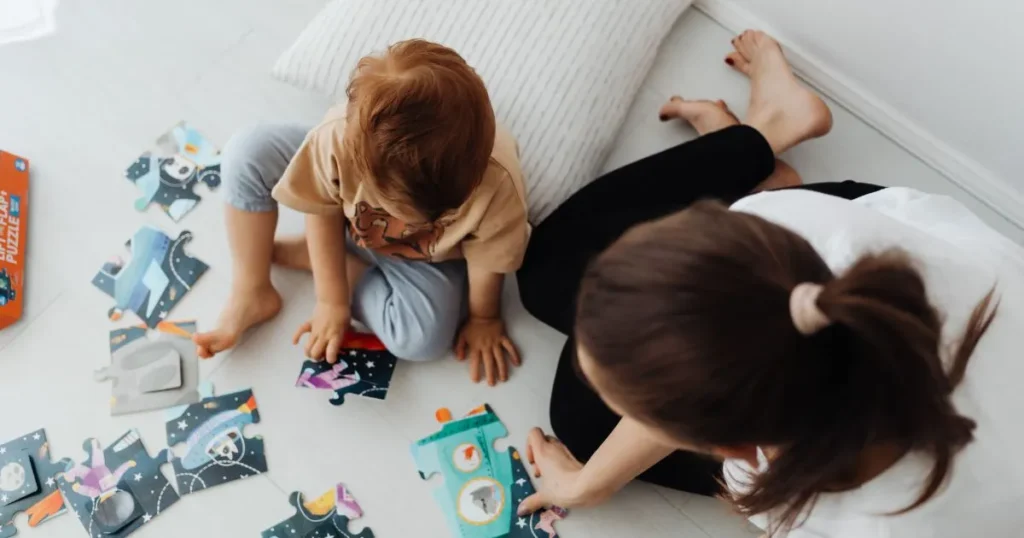 Parent helping a preschooler develop problem-solving skills through play.