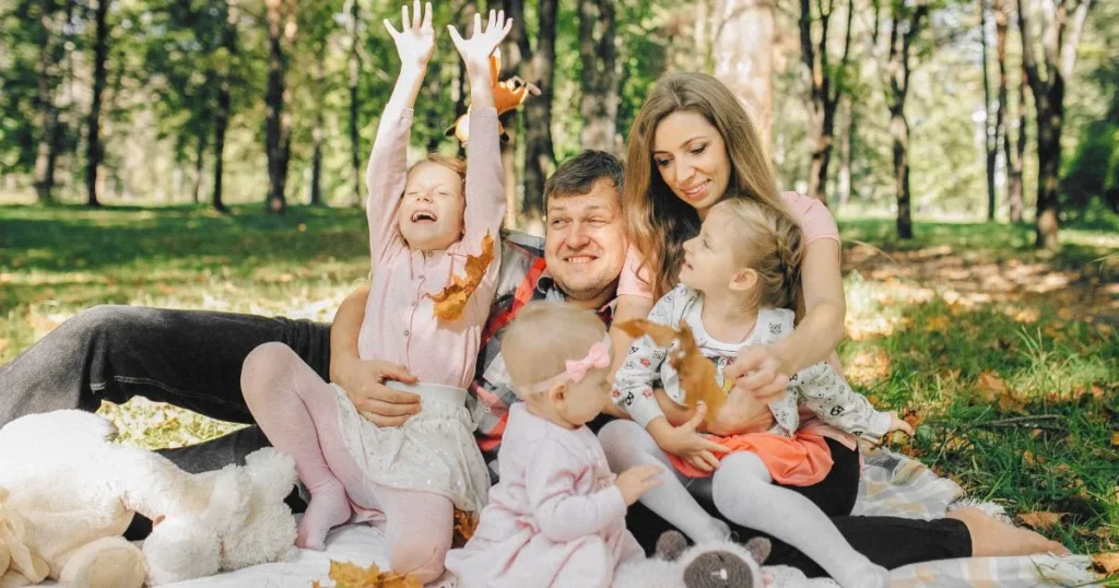 Parents and young child walking together in a park during golden hour, natural smiles, relaxed atmosphere, realistic family photography.