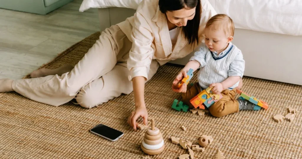 Mom putting down her phone to play with children