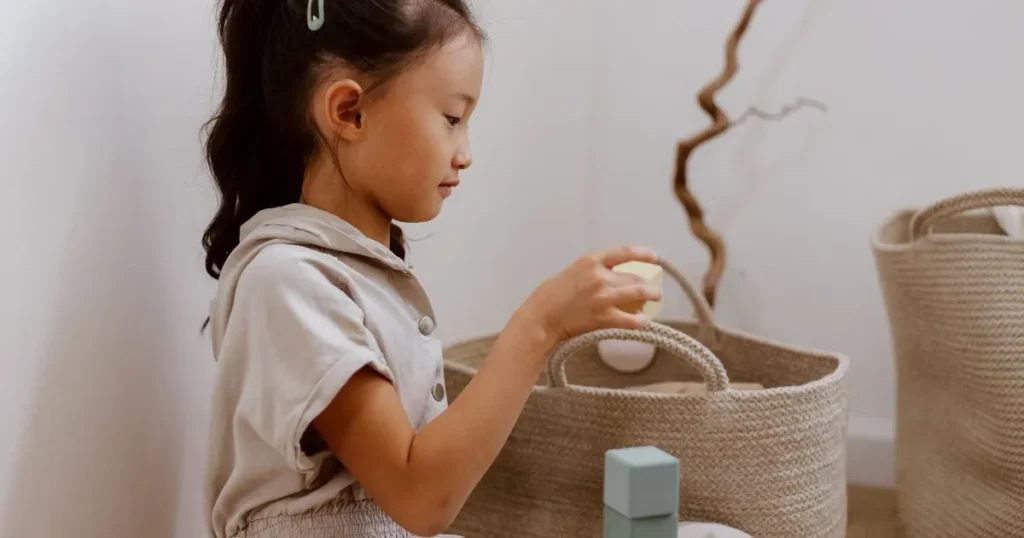 Parent encouraging responsibility by praising a child for cleaning up toys.