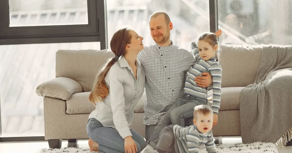 Family showing baby, toddler, child interacting with parents, warm home, realistic