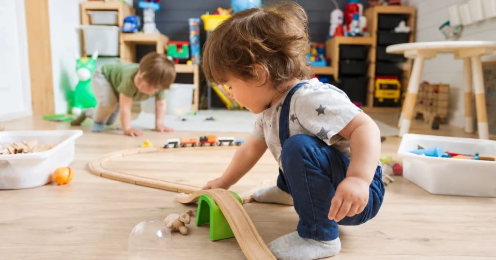 20 Easy Gross Motor Activities for Toddlers and Preschoolers 3 Toddler crawling through a homemade indoor obstacle course using cushions and pillows