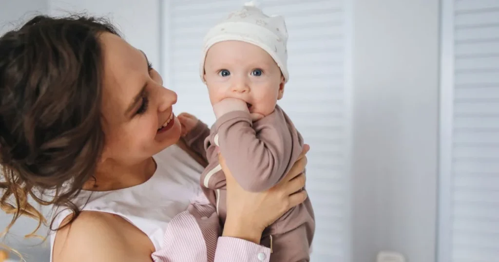 How to Burp a Baby: Step-by-Step Guide for Parents 5 Parent gently burping a newborn while the baby sits upright on their lap with head and neck supported
