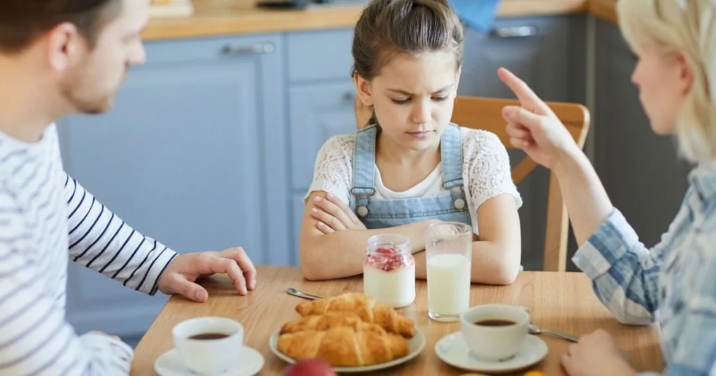 Authoritarian Parenting: Characteristics, Effects, and Healthier Alternatives 8 Parents explaining a rule to a child in an authoritarian parenting situation