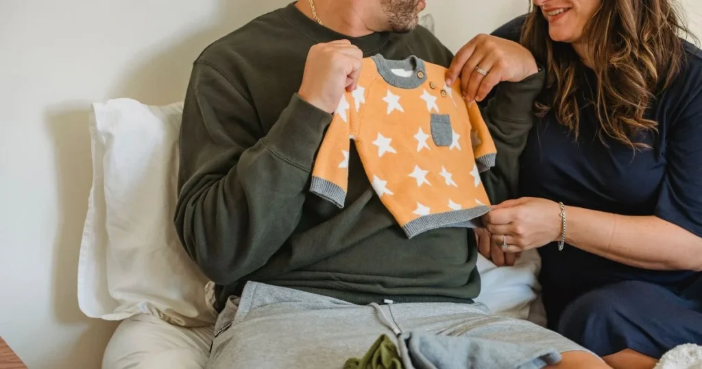Pregnant couple packing comfortable clothes, shoes, and travel essentials for a babymoon