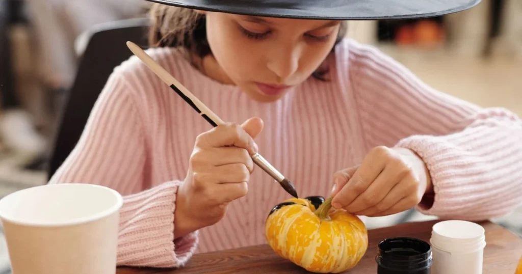 Halloween Activities for Kids: 20 Easy Ideas at Home 5 preschool children enjoying easy Halloween crafts and pumpkin decorating